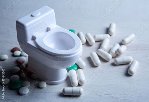 toilet bowl miniature and pills on the table