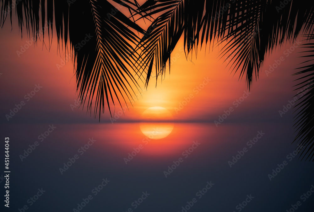Silhouette of beautiful sunset on the sea beach with palm tree for travel in holiday