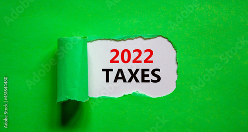 2022 taxes new year symbol. Words '2022 taxes' appearing behind torn green paper. Beautiful green background. Business, 2022 taxes new year concept, copy space.