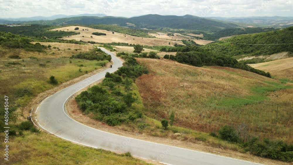 motorcyclist rides through beautiful italian landscape in summer motorcyclist rides through beautiful italian landscape in summer