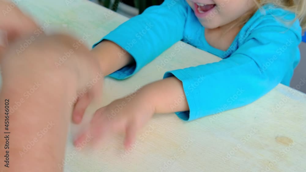 mom plays finger games with daughter, little child, girl 2 years old