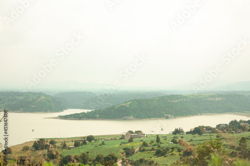 Lake fringed by mountains and hills shrouded in mist in Mexico state Coal Village