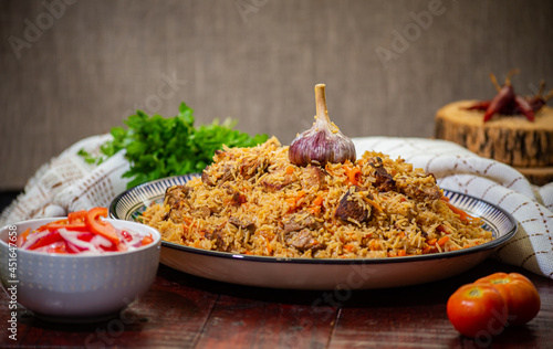 Delicious Fergana pilaf. Uzbek favorite dish on wooden background photo