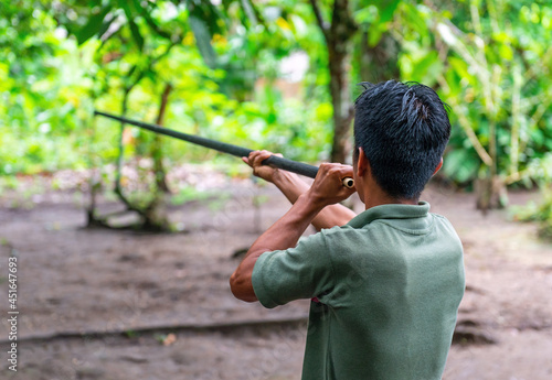 Ecuadorian indigenous Kichwa man doing a blowgun demonstration, traditional hunting method in the Amazon rainforest, Yasuni national park, Ecuador.