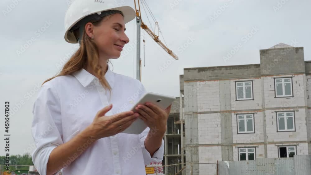 Female civil engineer using a tablet at her workplace on a construction site Female civil engineer using a tablet at her workplace on a construction site