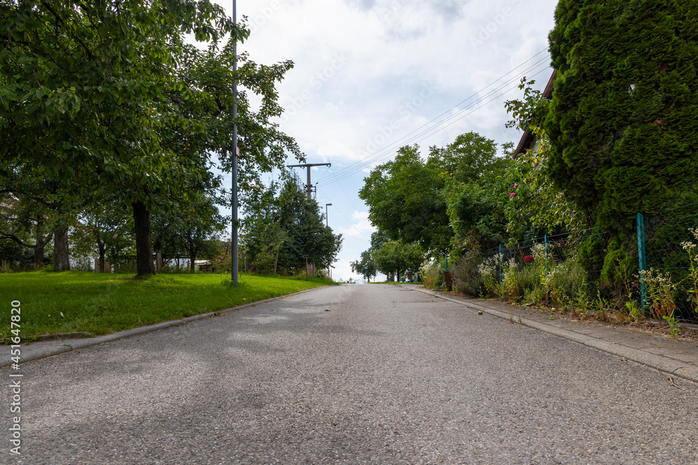 Village street between farm gardens and fruit tree meadows in the Swabian Jura Village street between farm gardens and fruit tree meadows in the Swabian Jura