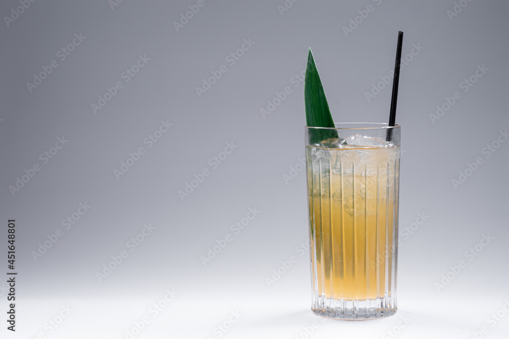 refreshing lemonade drink or cocktail with ice cube in glass on grey background refreshing lemonade drink or cocktail with ice cube in glass on grey background