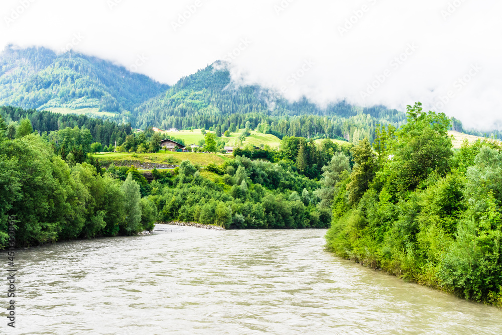 river in the woods and mountains with clouds