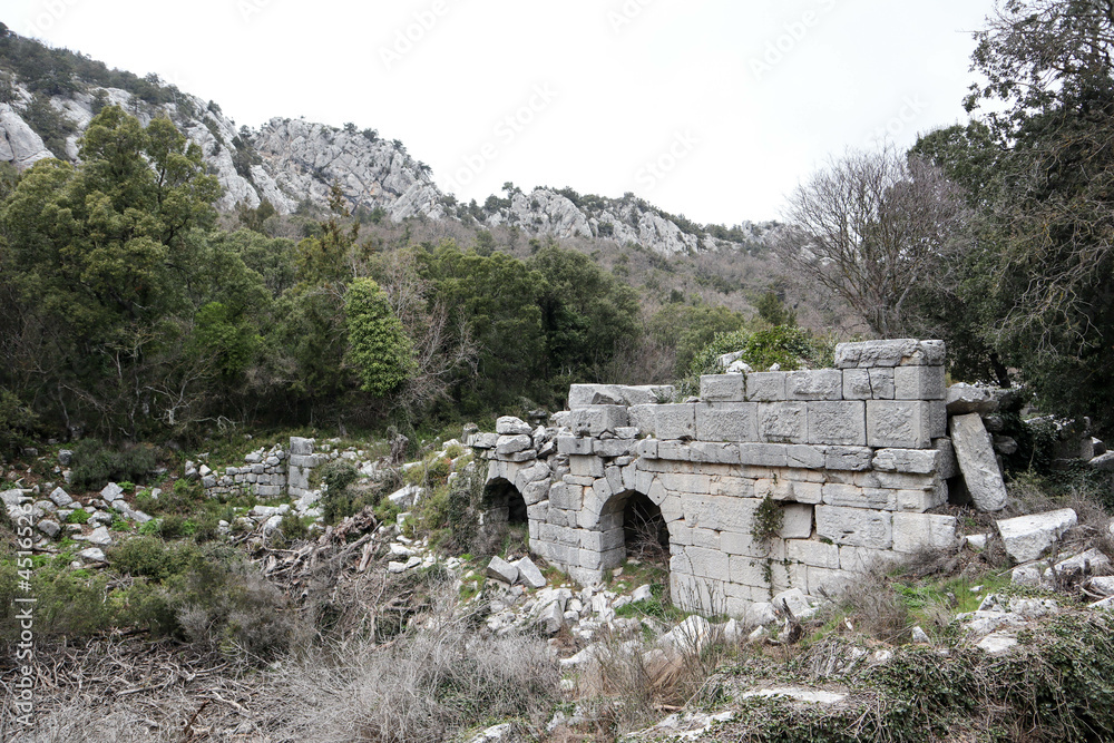 ruins of ancient building with arch in abandoned city Termessos that lost in Turkey mountains ruins of ancient building with arch in abandoned city Termessos that lost in Turkey mountains