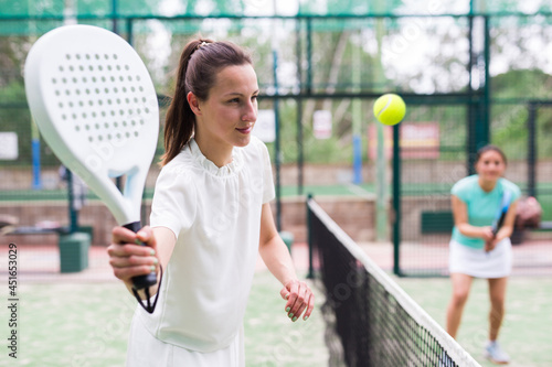 Portrait of smiling woman paddle tennis player during couple match at court