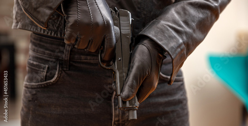 Bilde på lerret Gloved hand holding a pistol closeup view