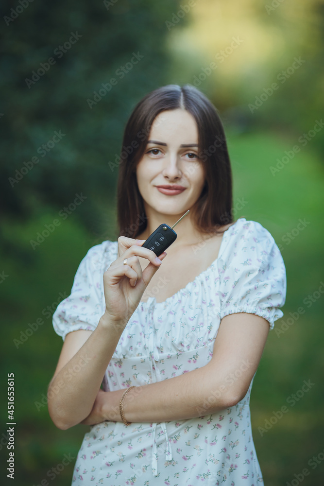 Young beautiful girl holding car keys in hand