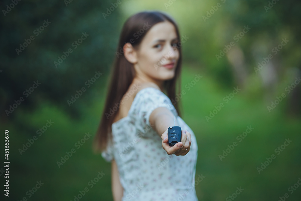 Young beautiful girl holding car keys in hand