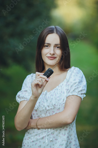 Obraz na płótnie Young beautiful girl holding car keys in hand
w salonie