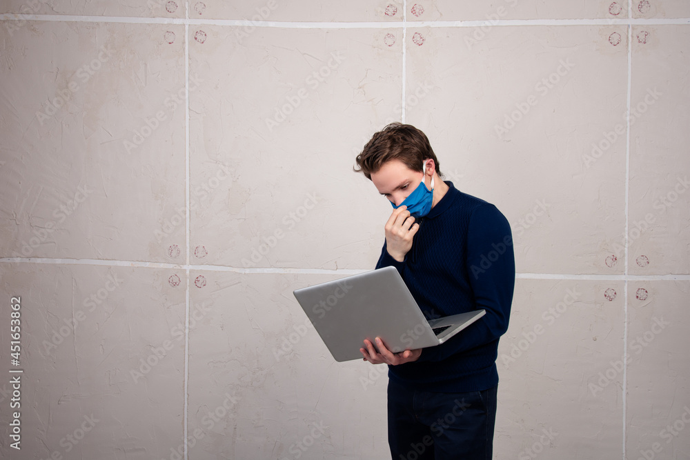 Young student in online classes. Web training. A man with a mask and a laptop in his hands.