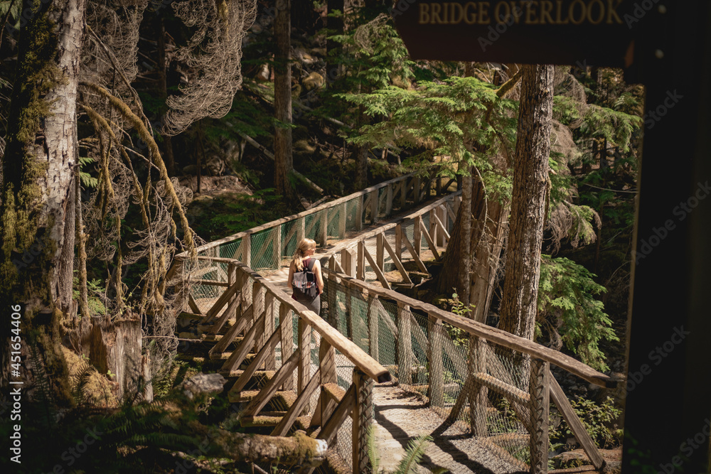 Woman walking along a bridge on the Ladder Creek Falls Trail in North Cascades National Park