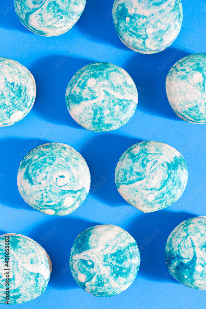 Blueberry swirl french macarons on a bright blue background