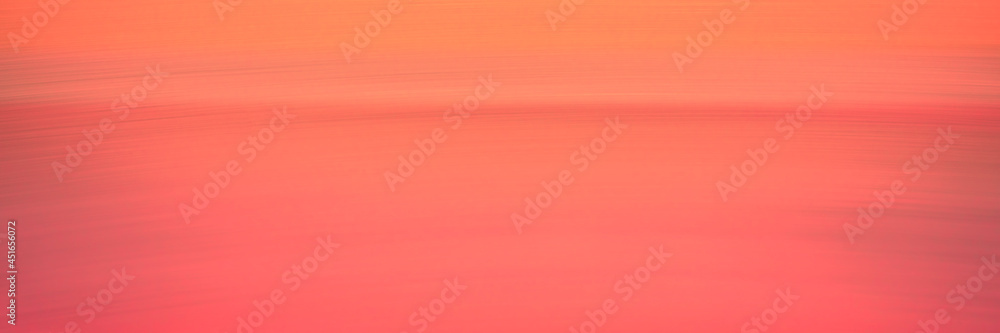 Fototapeta premium Peach-colored abstract wide seascape background. Warm sky and ocean with empty gradient motion blur backdrop. Cross-processed image of the tranquil twilight sea at Hyannis Harbor in Massachusetts.