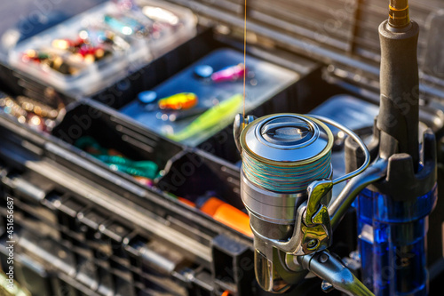 A large fisherman's tackle box fully stocked with lures and gear for fishing.fishing lures and accessories in the box background. © bukhta79