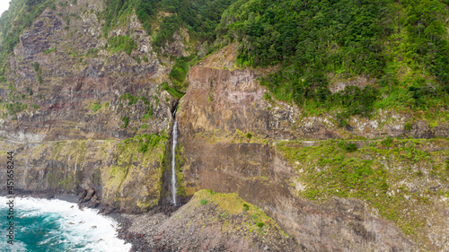 Fototapeta Naklejka Na Ścianę i Meble -  Waterfall falling into ocean from volcanic cliffs.