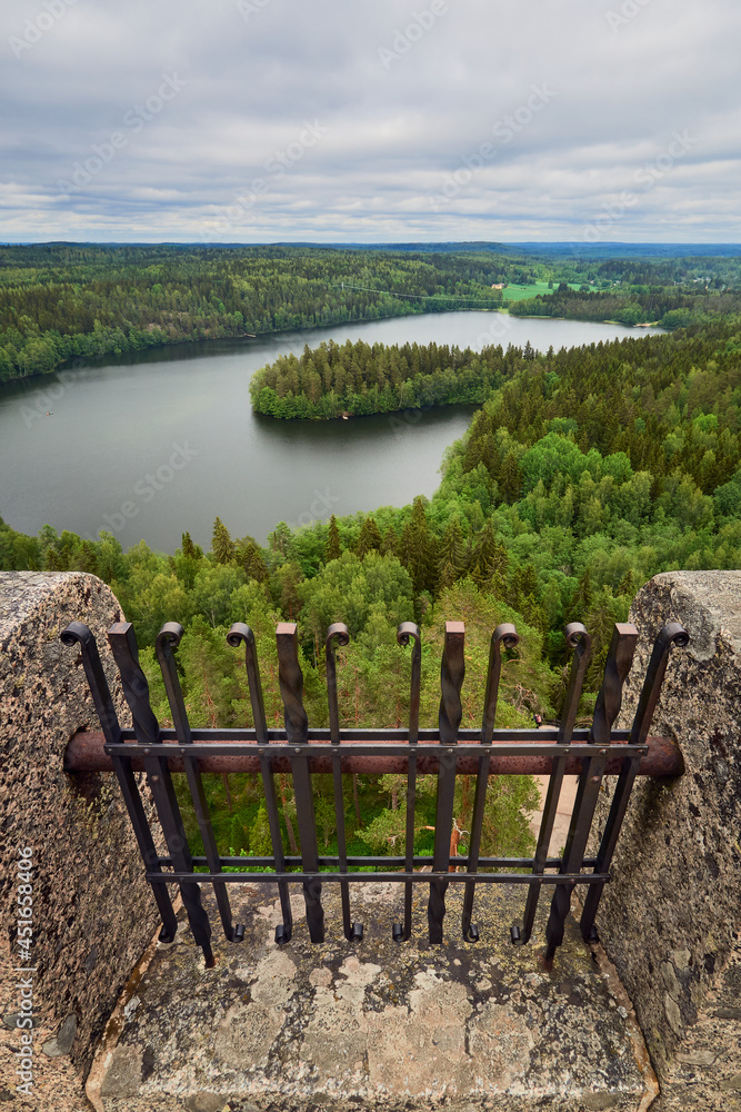 A vertical panorama from the top of the Aulanko tower near the Finnish town of Hamenlinna: the lattice of the tower, forests, lake, clouds. A vertical panorama from the top of the Aulanko tower near the Finnish town of Hamenlinna: the lattice of the tower, forests, lake, clouds.