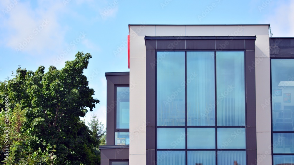 Modern building with windows and grey walls. Windows are reflecting light. Modern building with windows and grey walls. Windows are reflecting light.