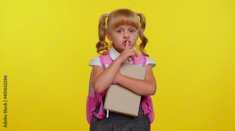 Shh be quiet please. Funny little pupil girl teenage student presses index finger to lips makes silence gesture sign do not tells secret on yellow studio background. Education, back to school, study Shh be quiet please. Funny little pupil girl teenage student presses index finger to lips makes silence gesture sign do not tells secret on yellow studio background. Education, back to school, study