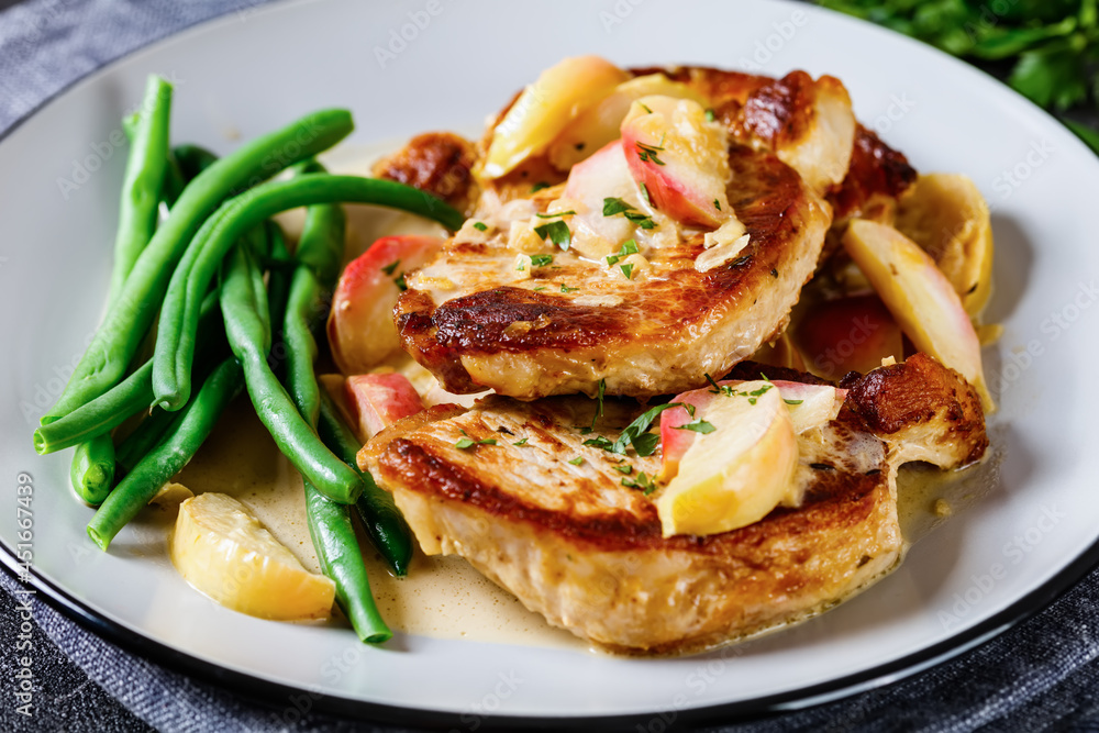 pork chops in apple cider cream sauce on a plate pork chops in apple cider cream sauce on a plate