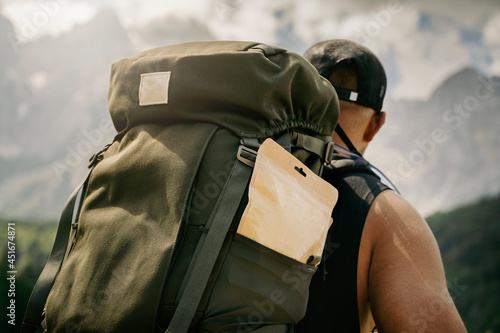 Strong Man with big backpack going on a hike, Alpine mountains in background