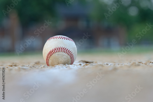 Photography Long telephoto image of a well worn baseball sitting on the foul line leading to