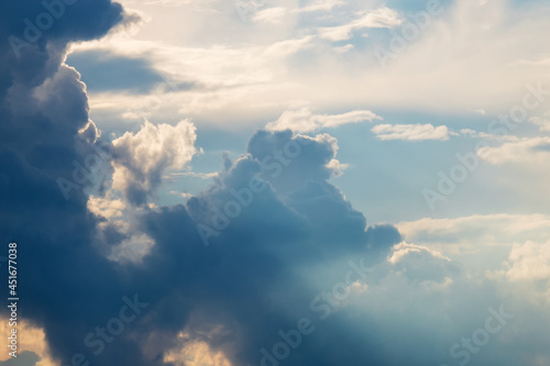 Canvas Print Sun rays against blue sky and dark clouds