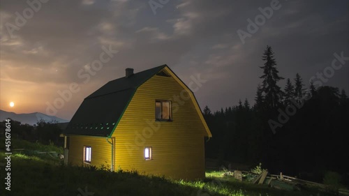 House in the mountains against the background of the starry sky and the moon. High quality 4k footage