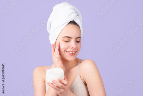 Cosmetic products. Beauty face portrait. Spa therapy, beautiful woman in towel takes care of skin.