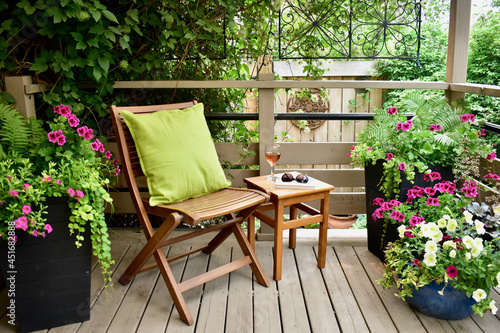 Fototapeta Naklejka Na Ścianę i Meble -  Outdoor oasis setting in secluded backyard deck at summer vacation rental in lush, luxury setting for relaxing with wine in beautiful landscaped garden