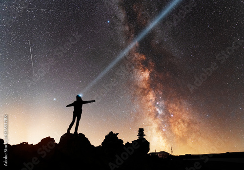 Beautiful starry night,  silhouette of the hiker looks at the Milky Way galaxy. Night landscape, astronomical background. © Inga Av