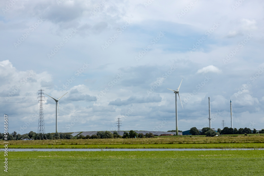 Sustainable wind turbine energy mills in Dutch river IJssel valley landscape. Bioenergy and sustainability concept. Sustainable wind turbine energy mills in Dutch river IJssel valley landscape. Bioenergy and sustainability concept.