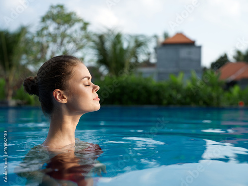woman on vacation swims in the transparent water of the pool summer landscape model