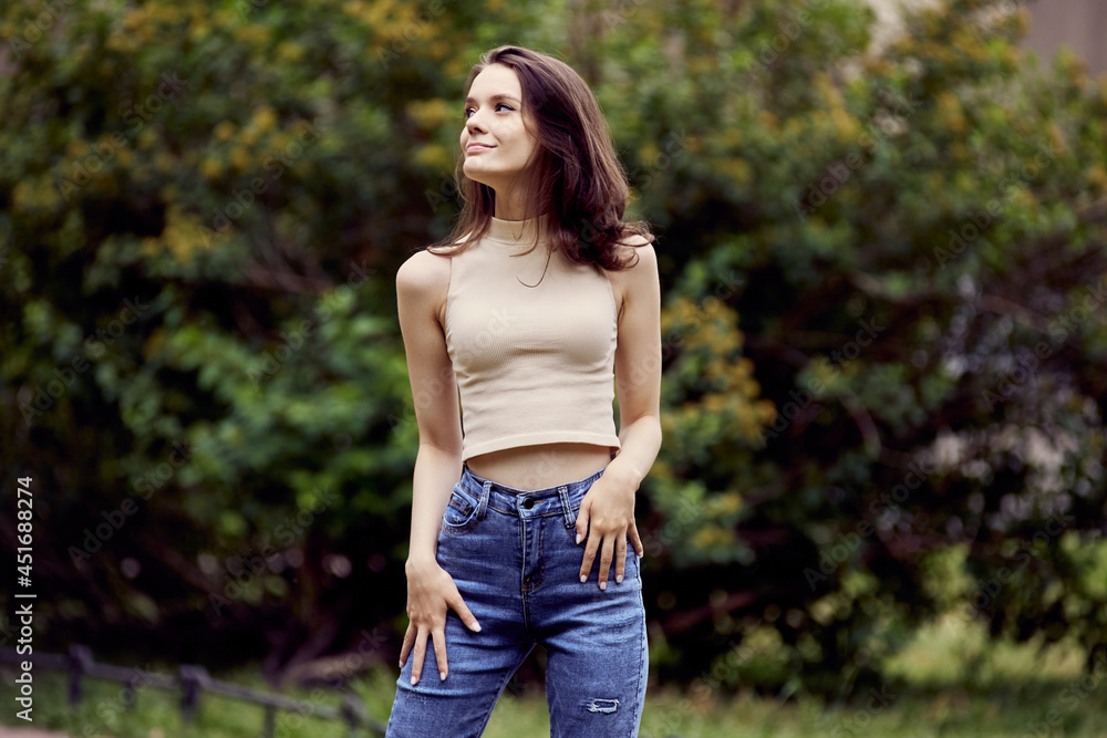 Happy young woman in jeans walks in park. Happy young woman in jeans walks in park.