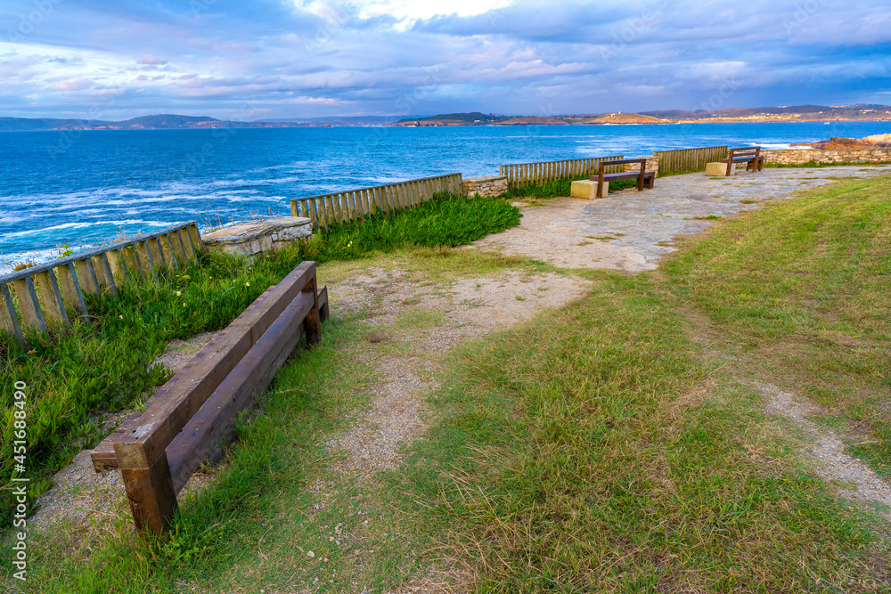 Obraz premium Wooden benches in Hercules Tower coast (La Coruna, Spain).