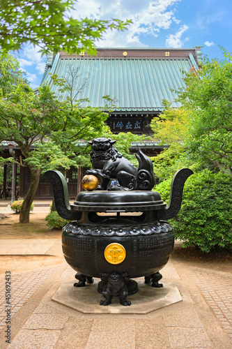 Japanese Buddhist censer at the hall of Gotokuji temple with a Tachibana orange crest of Ii clan above demons overlooked by tamatori shishi lion with a golden mari ball. photo
