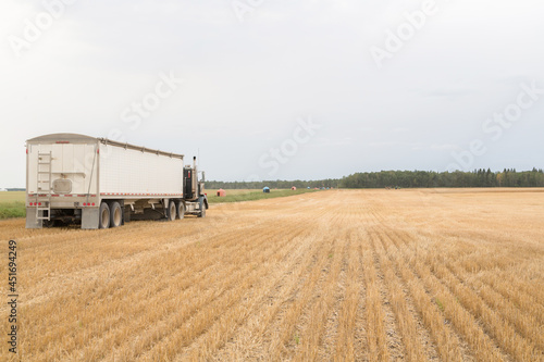 side view of a semi trailer truck in a farm field
