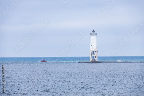 Frankfort North breakwater lighthouse and boat in background, Lake Michigan, Michigan, USA