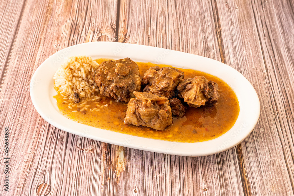 tray of oxtail stew cooked with Spanish recipe accompanied by white rice tray of oxtail stew cooked with Spanish recipe accompanied by white rice