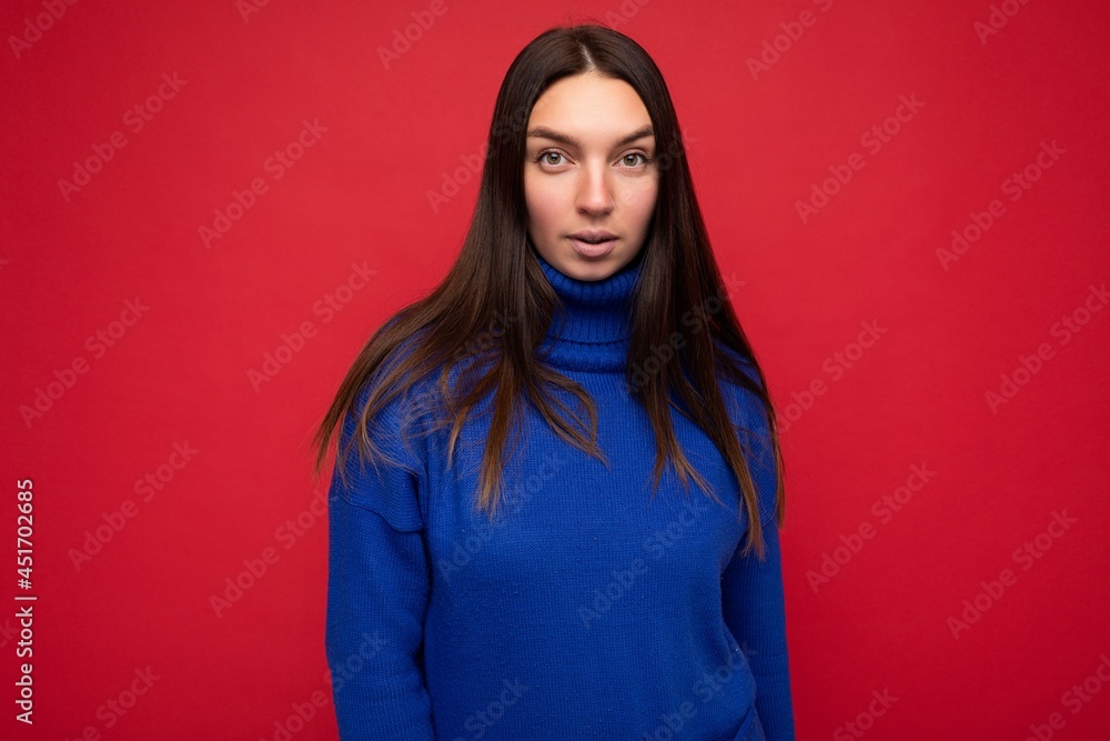 Adult calm serious pretty brunet woman with sincere emotions isolated on background wall with copy space wearing casual trendy blue sweater Adult calm serious pretty brunet woman with sincere emotions isolated on background wall with copy space wearing casual trendy blue sweater
