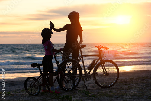 Biker family silhouette   family at the beach at sunset.  biker family happy relations. Lifestyle Concept
