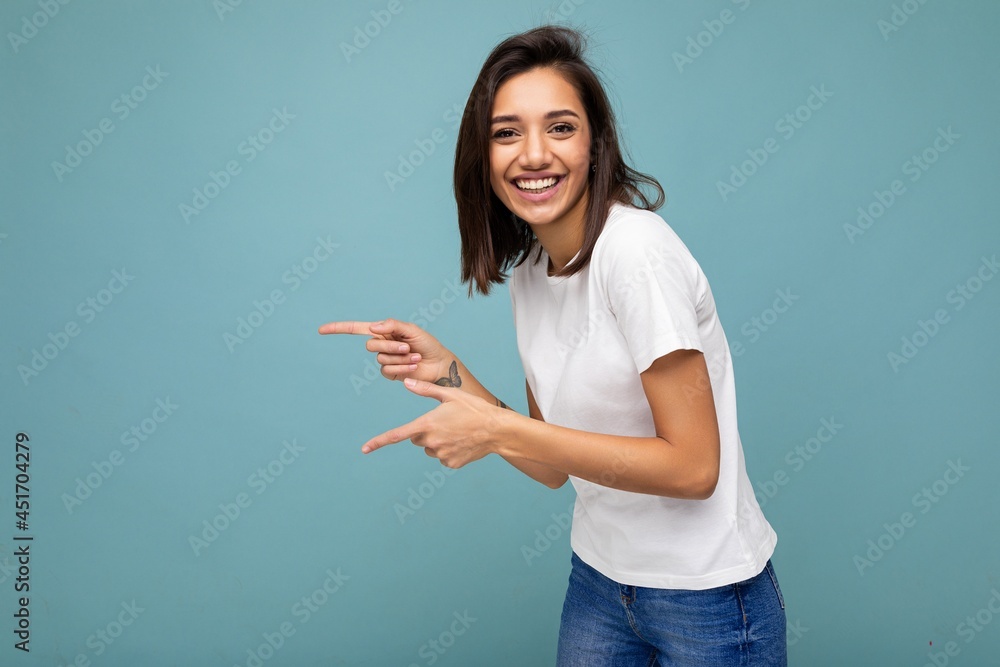 Portrait of beautiful fascinating emotional positive joyful happpy female promoter pointing to the side at copy space for advertising wearing hipster outfit isolated over background wall with empty Portrait of beautiful fascinating emotional positive joyful happpy female promoter pointing to the side at copy space for advertising wearing hipster outfit isolated over background wall with empty