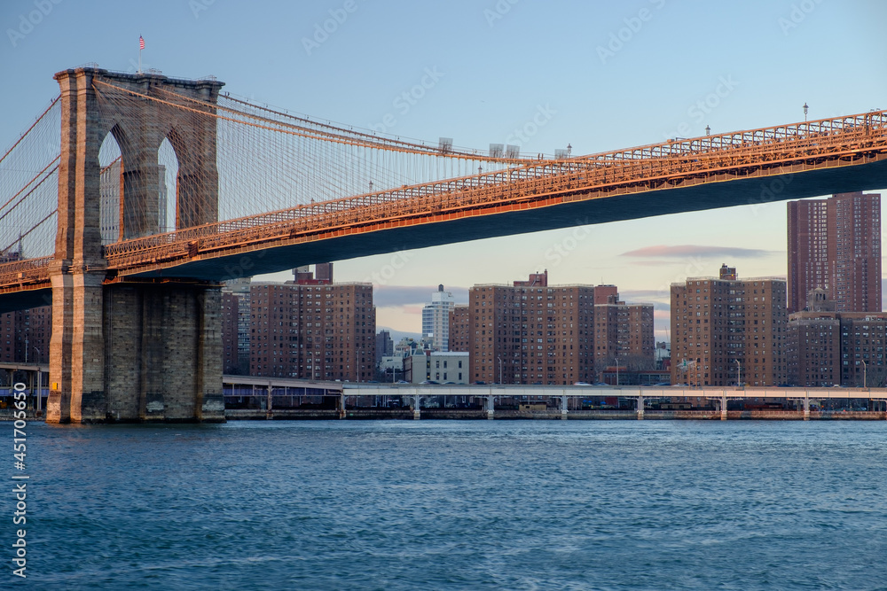 Brooklyn Bridge spanning the East River from Brooklyn into New York City at sundown