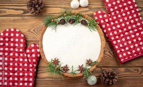 Fototapeta Naklejka Na Ścianę i Meble -  Festive cake with white cream decorated with cones, coniferous branches and star anise. Concept of the New Year and Christmas. Copy space and top view