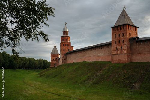 View of the wall of the Novgorod Kremlin, the Knyazhaya Tower, the Kokui Tower and the Pokrovskaya Tower on an early cloudy summer morning, Veliky Novgorod, Novgorod Region, Russia photo