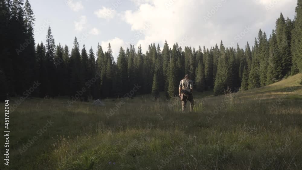 Hiker walking through a clearing. Hiker walking through a clearing.